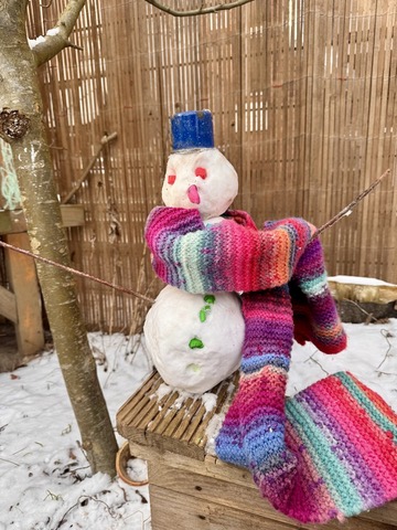 Schneemann mit buntem Schal im Kita-Garten